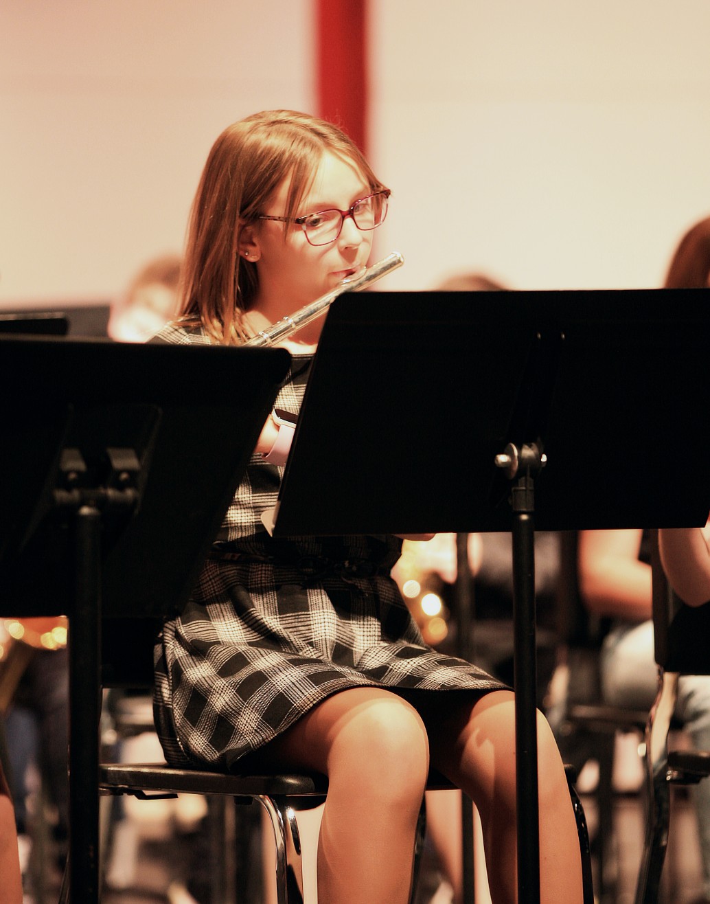 Student playing flute behind a music stand