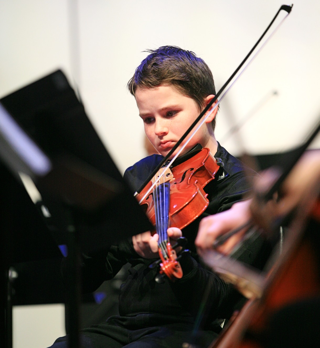 Student focused on reading music while playing violin