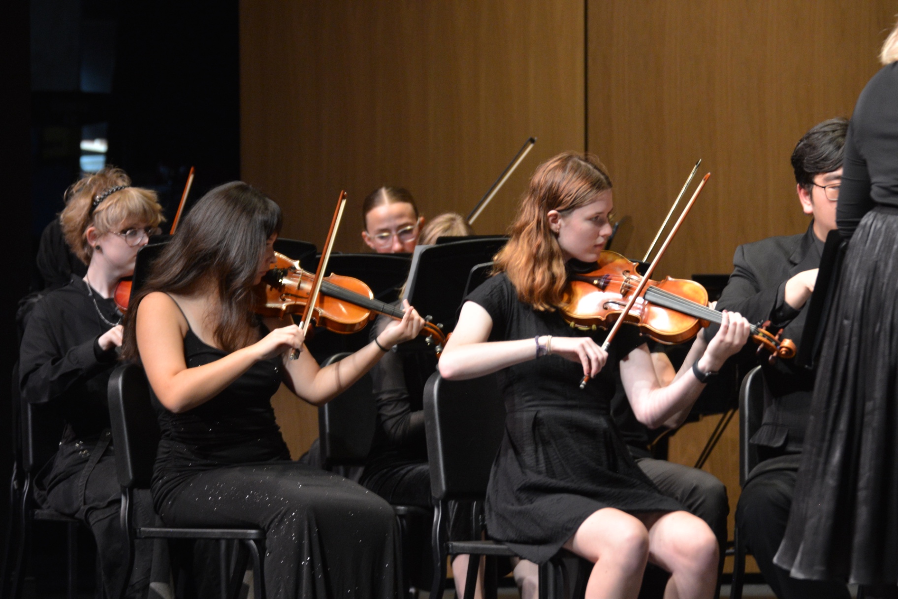Two violinists performing together on stage