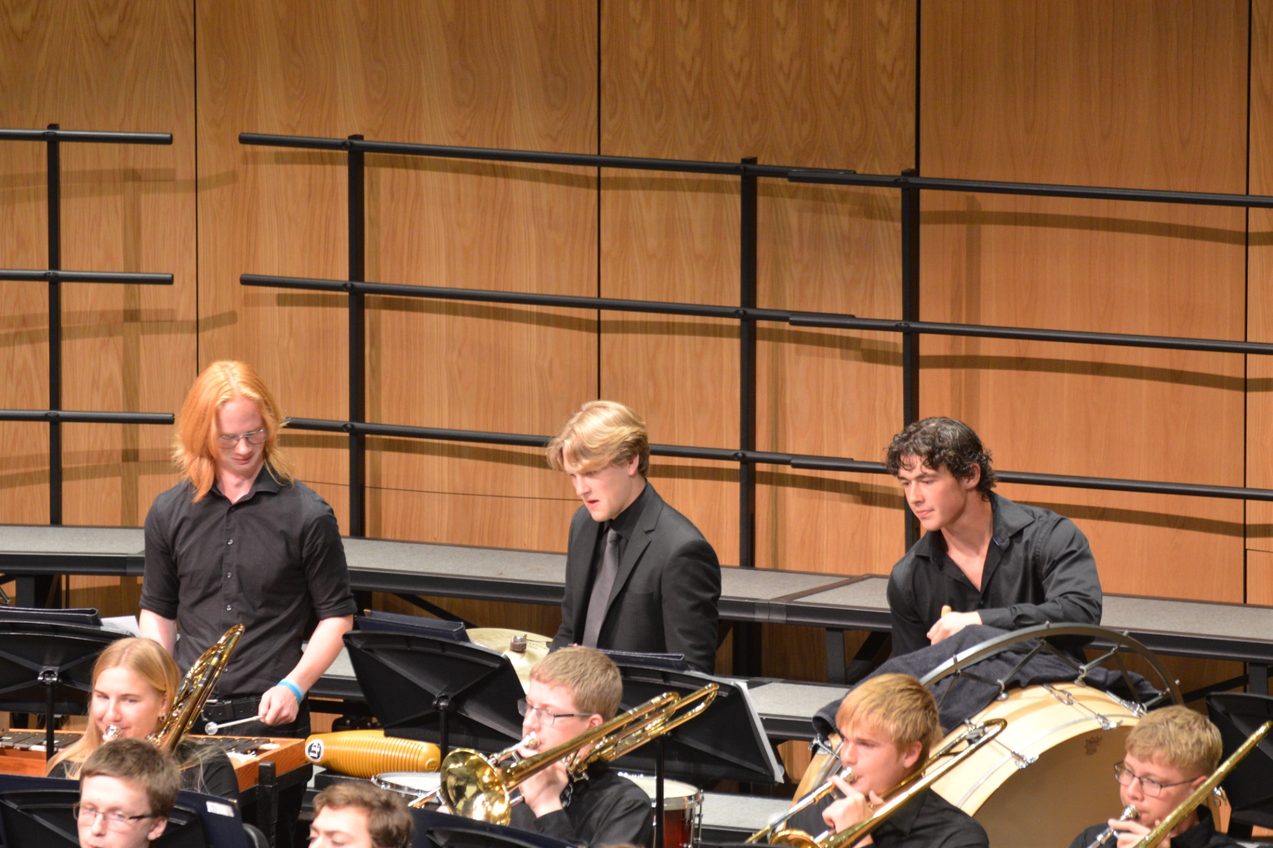 Percussion students performing behind the concert band